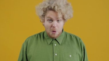 Yakından bakınca, sarı arka planda el hareketi yapan yakışıklı blogcu görülüyor. Halk ve reklam kavramı.