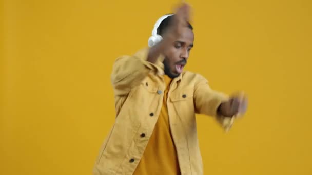 Πορτρέτο Του Χαρούμενου Αφροαμερικανού Που Φοράει Ακουστικά Χορεύοντας Κίτρινο Φόντο — Αρχείο Βίντεο