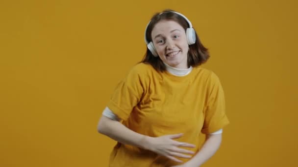아름다운 여자가 동작으로 헤드폰을 노란색 음악을 즐거움을 선사합니다 사람들 — 비디오