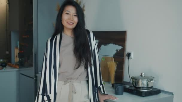 站在厨房里穿着舒适衣服的亚洲家庭主妇慢镜头 微笑着看着相机 人与公寓概念 — 图库视频影像