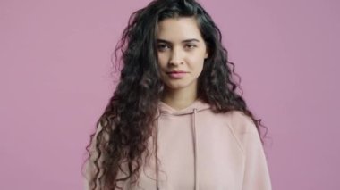 Sevimsiz kadın vlogger portresi pembe arka planda işaret ve el hareketi gösteriyor. Halk ve sosyal medya kavramı.