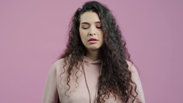 不幸な若い女性がため息をつくとピンクの色の背景に悲しみとカメラを見てのスローモーションの肖像画 感情と表現の概念 — ストック動画