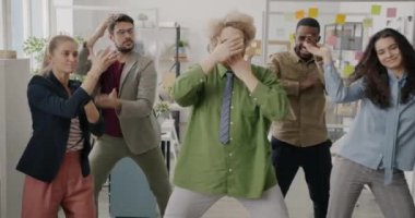 Bir grup komik genç ofis çalışanı gündüz vakti cam duvar odasında dans ediyor ve tatilin tadını çıkarıyorlar. İnsanlar ve yaratıcı iş yeri konsepti.