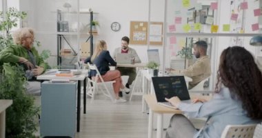 Çılgın eleman, iş yerinde eğlenen meslektaşlarına kağıt toplar atıyor. Neşeli gençlik ve işyeri konsepti.