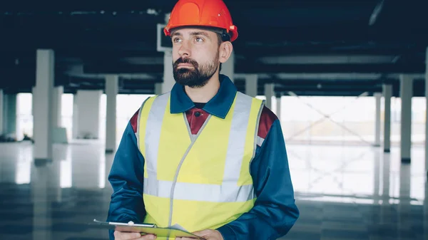 Byggnadsinspektören Som Bär Uniform Kontrollerar Papper Och Studerar Industribyggnader Inomhus — Stockfoto