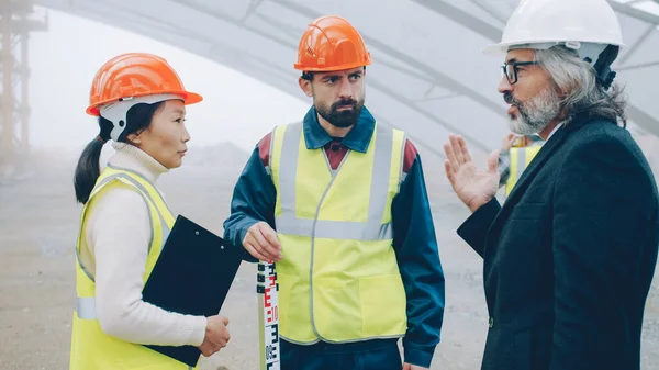 Byggare Uniform Pratar Byggarbetsplatsen Medan Arkitekt Kostym Och Hjälm Kommer — Stockfoto