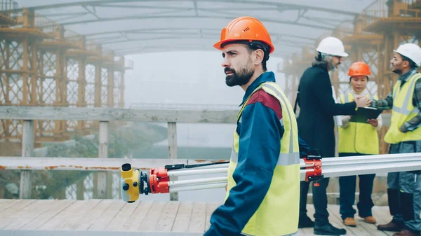 Serious Male Surveyor Uniform Walking Construction Site Holding Theodolite Concentrated — Stock Photo, Image