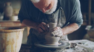 Seramik kavanoz bitmedi potterss tekerlek ve erkek eller kil profesyonel araçlar ile kalıplama iplik yakın çekim shot. Eathenware ve geleneksel seramik konsept oluşturma.