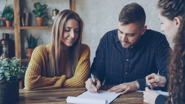 Immobilienmaklerin Liest Kauf Und Verkaufsvertrag Für Junges Paar Mann Unterschreibt — Stockfoto