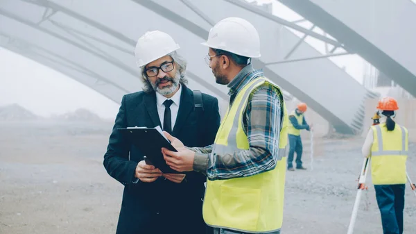 Projektový Manažer Hovoří Stavitelem Stavebních Pracích Buiding Area Pomocí Tabletu — Stock fotografie