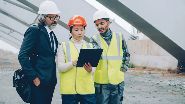 Grupo Multiétnico Personas Arquitectos Están Leyendo Periódicos Planos Hablando Pie — Foto de Stock