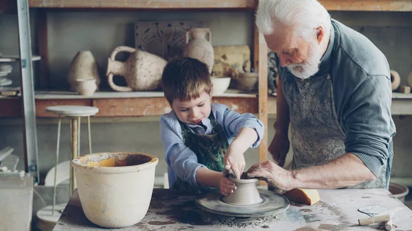 Konsentrert Liten Gutt Lærer Arbeide Med Leire Profesjonelle Kastehjul Keramikkurs – stockfoto