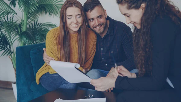 Adorable Couple Vérifie Les Papiers Lors Réunion Avec Agent Immobilier Images De Stock Libres De Droits