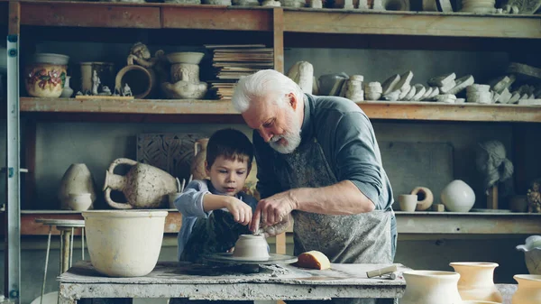 Заботливый Старший Дедушка Показывает Юному Симпатичному Внуку Работать Глиной Метательном — стоковое фото