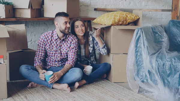 Glada Par Sitter Golvet Ett Nytt Hus Och Diskuterar Interiören — Stockfoto