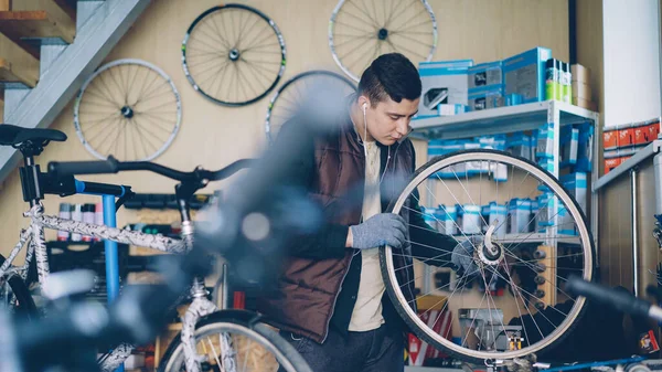 정비사는 메커니즘의 작품을 작업실에서 음악을 자전거 바퀴를 합니다 사람들이 — 스톡 사진