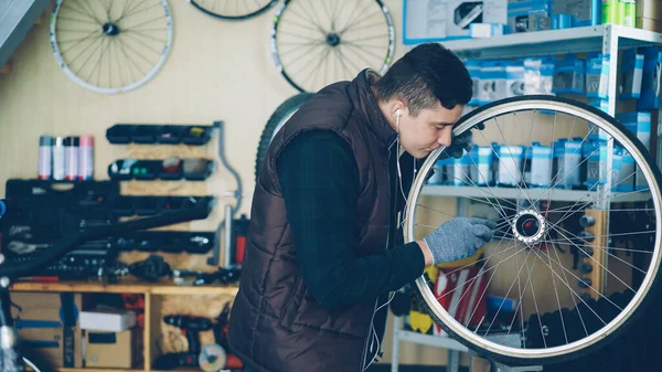 Fiatal Szerelő Kívül Belül Kerékpárt Tisztít Szerszámokkal Fülhallgatóval Zenét Hallgat — Stock Fotó