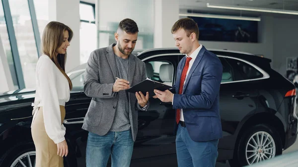 Handsome Young Guy Signing Sale Purchase Agreement Car Dealership — Stock Photo, Image