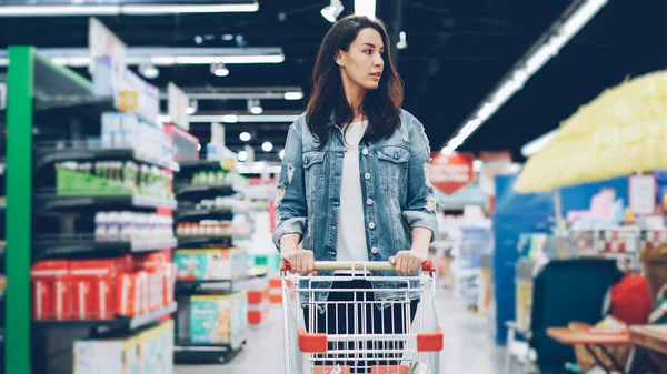 Die Junge Zierliche Brünette Läuft Einem Verbrauchermarkt Schiebt Einkaufswagen Lebensmittel — Stockfoto