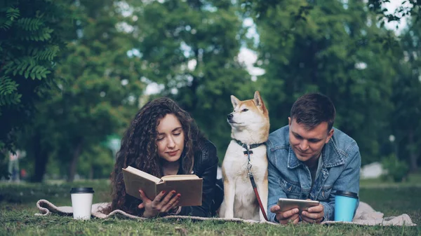 Mutlu Genç Çiftimiz Parkta Dinleniyor Kadın Kitap Okurken Erkek Smartphone — Stok fotoğraf