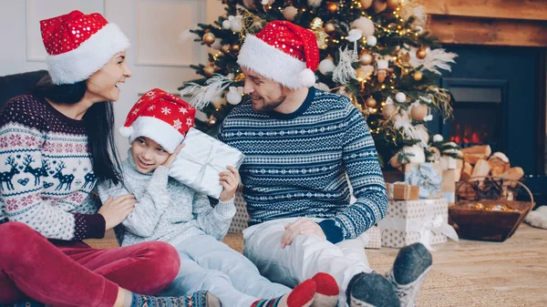 Liefdevolle Ouders Nieuwjaarshoed Geven Cadeautje Aan Gelukkig Jongetje Kerstavond Thuis — Stockfoto