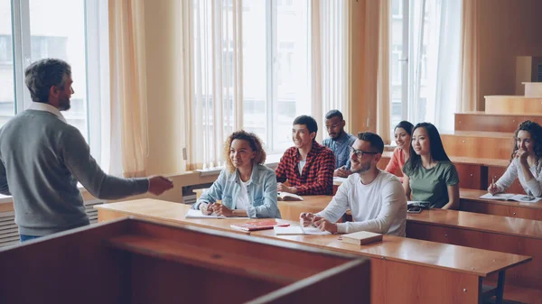 Doświadczony Nauczyciel Rozmawia Wesoły Studentów Podczas Atrakcyjnych Młodych Ludzi Słucha — Zdjęcie stockowe