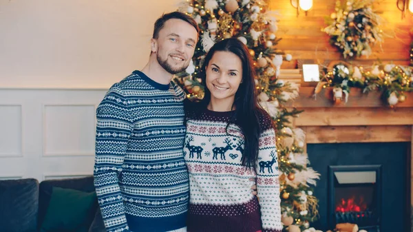 幸せなカップルの男性と女性の肖像画一緒にクリスマスの夜笑顔で立って カメラを見て 人々は暖かいセーターを着ている — ストック写真