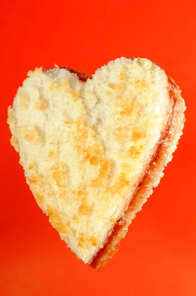 Herzförmiges Marmeladensandwich auf rotem Hintergrund — Stockfoto