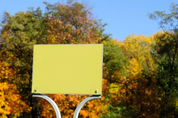 Plaque de signalisation vierge sur fond d'arbre d'automne lumineux — Photo