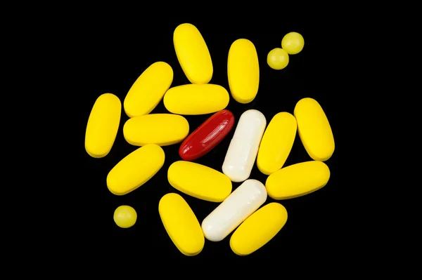 Tablety a kapsle na černém pozadí — Stock fotografie