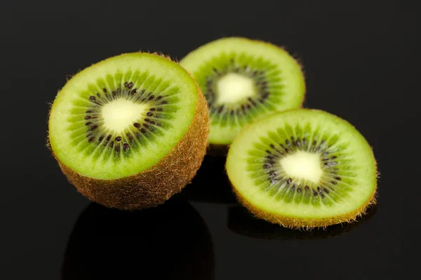 Kiwi vruchten segmenten op zwarte achtergrond — Stockfoto
