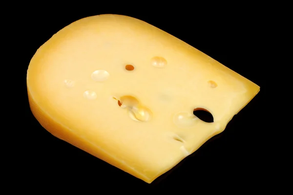 Pedazo de queso sobre fondo negro — Foto de Stock