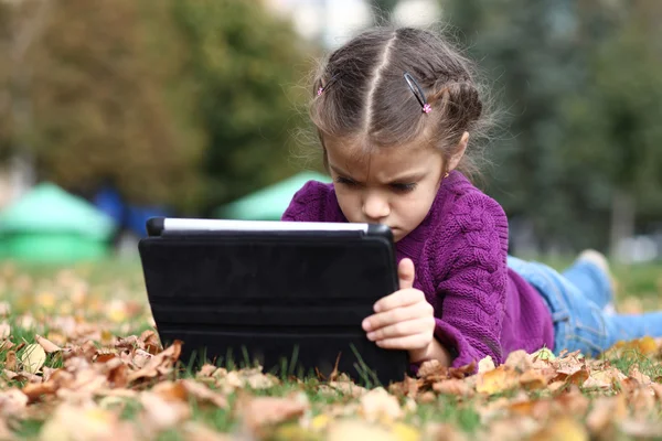 Klein meisje houden digitale tabletcomputer — Stockfoto