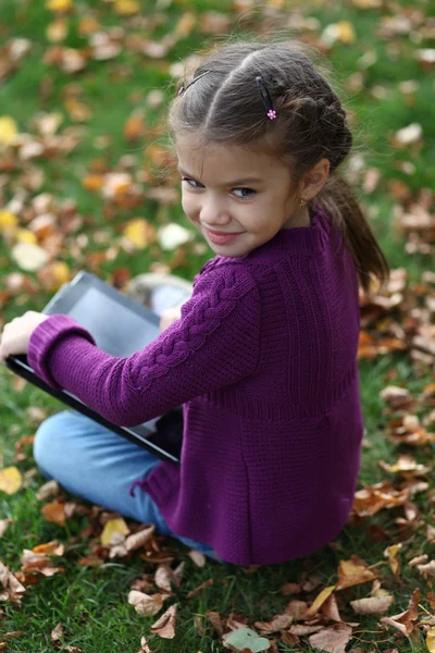 Klein meisje houden digitale tabletcomputer — Stockfoto