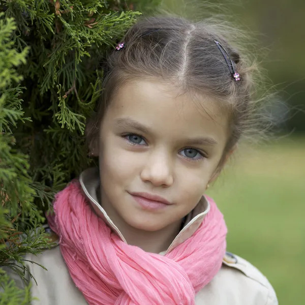 Retrato de una hermosa chica en una bufanda rosa — Foto de Stock