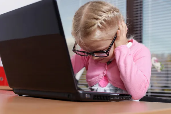 Klein meisje met laptop in kantoor — Stockfoto