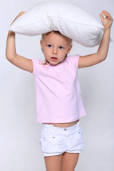 Petite fille avec un oreiller sur la tête — Photo