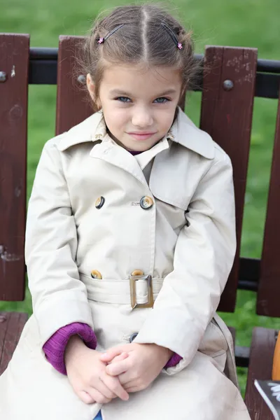 Little girl sitting on a bench — Stock Photo, Image