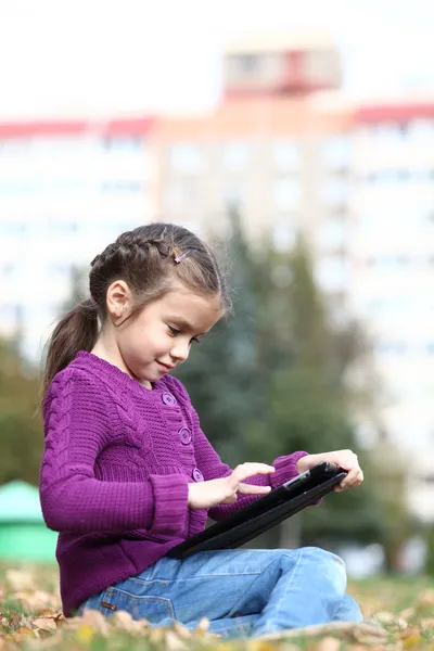 Klein meisje houden digitale tabletcomputer — Stockfoto