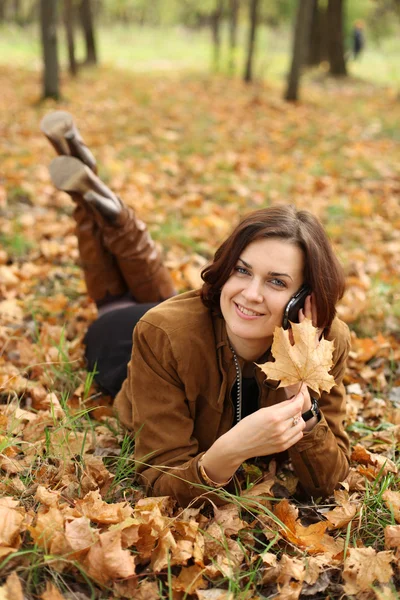 Žena volá po telefonu v podzimním parku — Stock fotografie