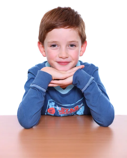 Schöner kleiner Junge sitzt am Tisch — Stockfoto