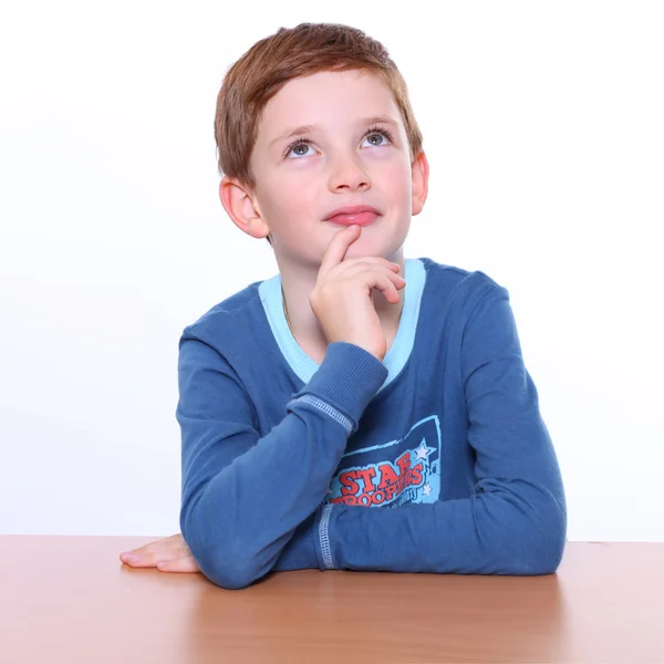 Beautiful little boy sitting at the table — Stock Photo, Image