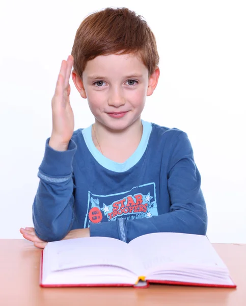 Prachtige kleine jongen zitten aan de tafel — Stockfoto