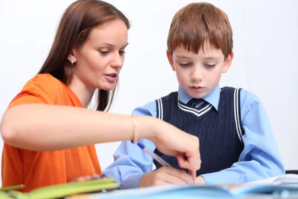 Madre o maestra ayudando a los niños con el trabajo escolar —  Fotos de Stock