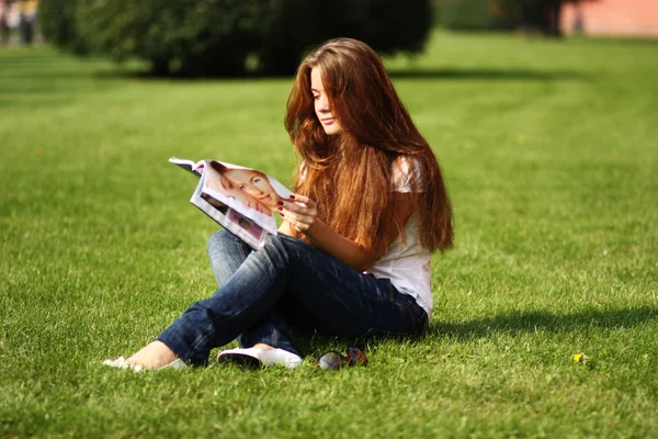 Porträt einer jungen schönen Frau, die Zeitschrift liest — Stockfoto