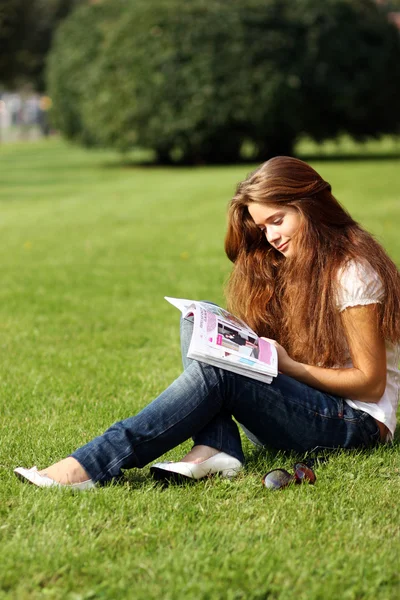 Porträt einer jungen schönen Frau, die Zeitschrift liest — Stockfoto