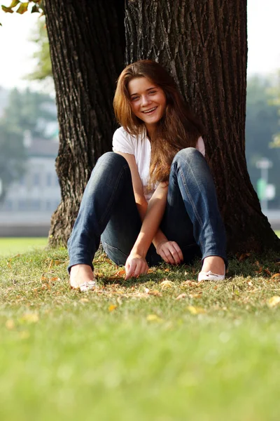 Mooi meisje zit op gras — Stockfoto