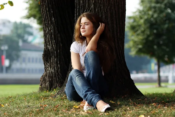 Gyönyörű lány ül a fűben — Stock Fotó