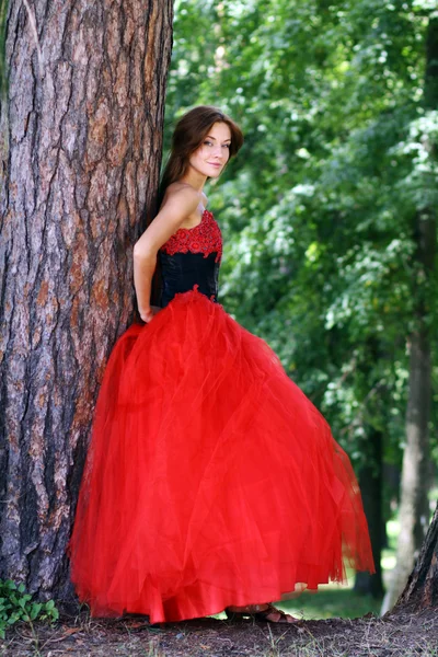 Mladá žena v červené gotické šaty — Stock fotografie