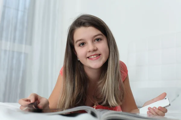 Little girl turning over the pages of magazines — Stock Photo, Image